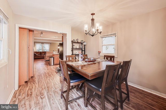 dining room with plenty of natural light, wood finished floors, and baseboards