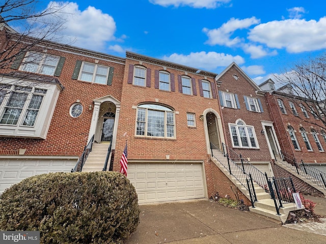 townhome / multi-family property featuring concrete driveway, brick siding, and an attached garage