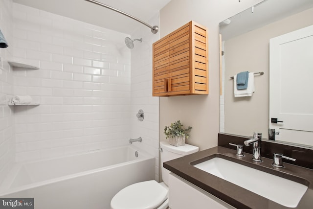 full bathroom featuring vanity, tiled shower / bath, and toilet