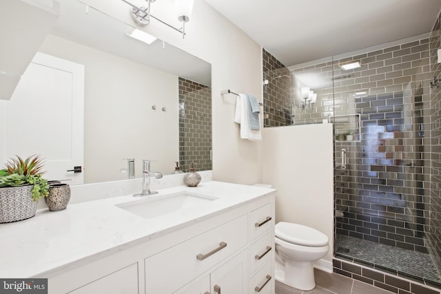 bathroom featuring vanity, an enclosed shower, and toilet