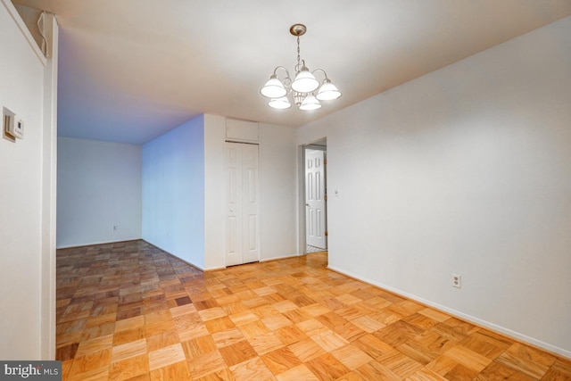 unfurnished room with an inviting chandelier and light parquet floors