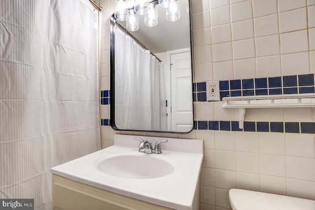 bathroom featuring toilet, sink, and tile walls