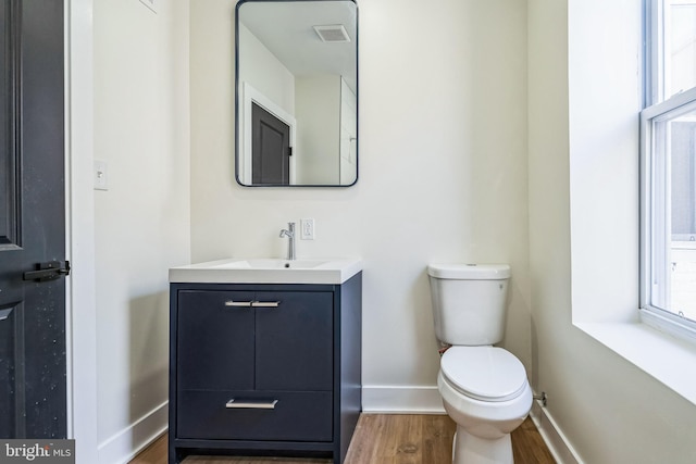 bathroom with vanity, toilet, and hardwood / wood-style floors