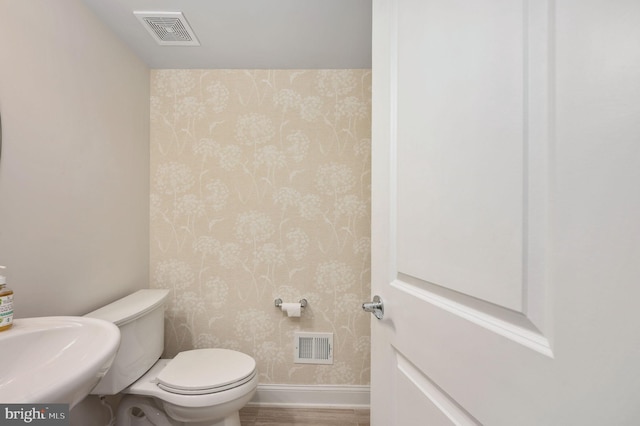 bathroom featuring hardwood / wood-style flooring, sink, and toilet