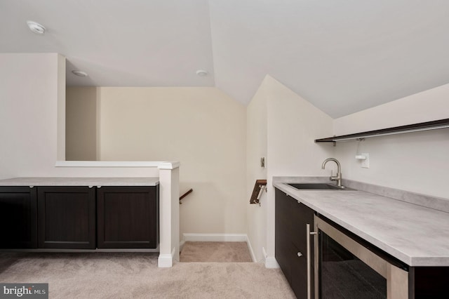 bar featuring vaulted ceiling, beverage cooler, sink, and light carpet