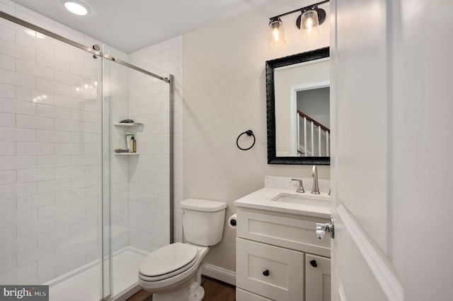 bathroom with vanity, hardwood / wood-style floors, a shower with shower door, and toilet