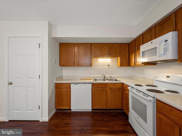 kitchen with white appliances, sink, and dark hardwood / wood-style flooring