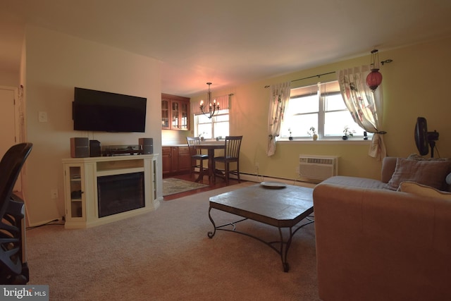 living room with a wall mounted air conditioner, a chandelier, a baseboard heating unit, and carpet floors