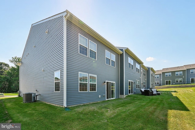 back of property featuring central AC and a yard