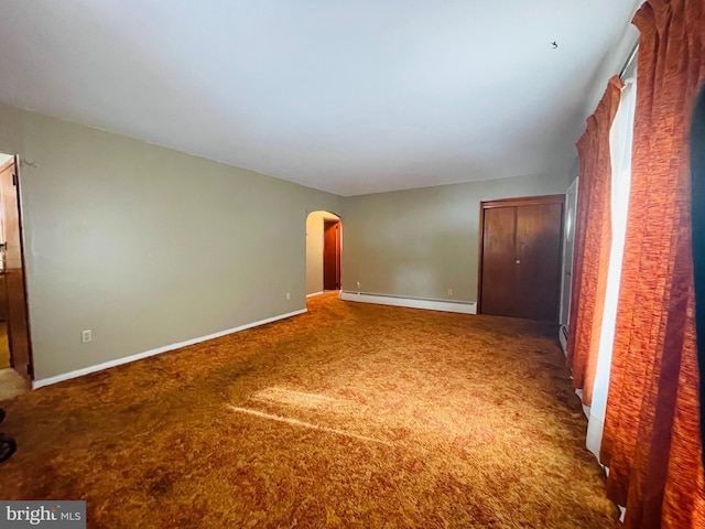 carpeted spare room featuring baseboard heating