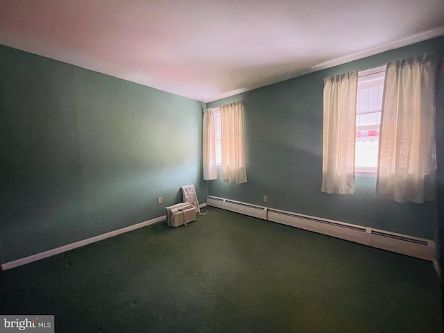 carpeted empty room featuring baseboard heating and plenty of natural light