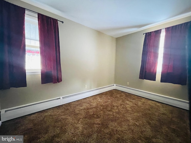 carpeted empty room featuring baseboard heating