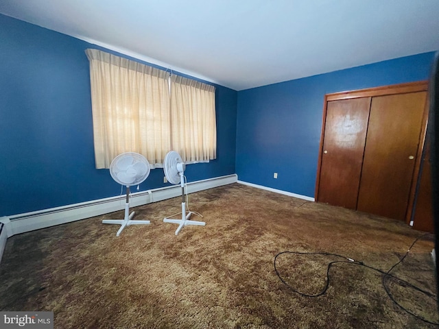 unfurnished bedroom featuring carpet, baseboard heating, and a closet