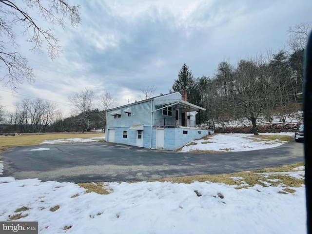 view of snowy exterior featuring a garage