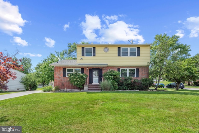 colonial inspired home with a front lawn and brick siding