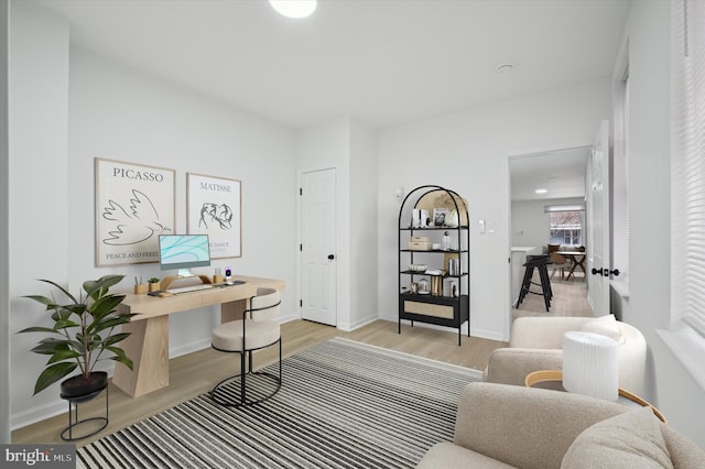 office with baseboards and light wood-style floors