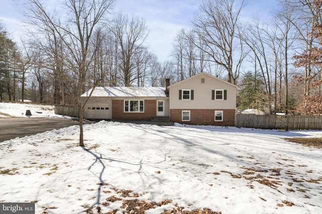 snow covered house featuring a garage