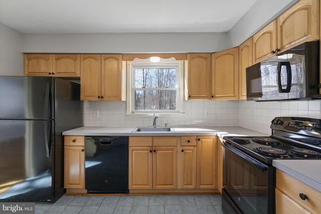 kitchen with light brown cabinetry, sink, decorative backsplash, and black appliances