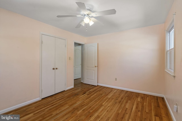 unfurnished bedroom with light hardwood / wood-style floors, a closet, and ceiling fan