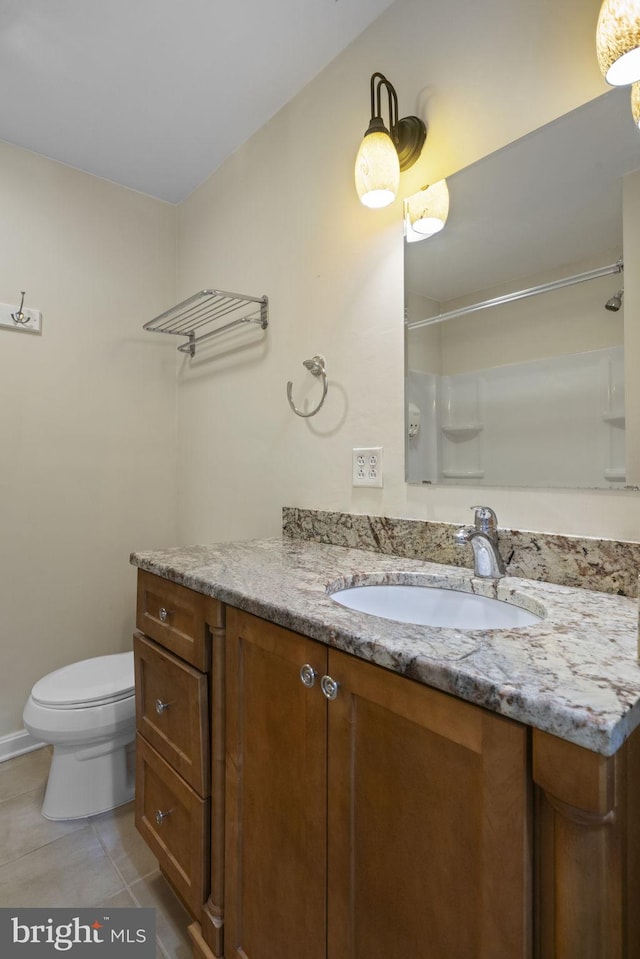 bathroom featuring vanity, a shower, tile patterned floors, and toilet