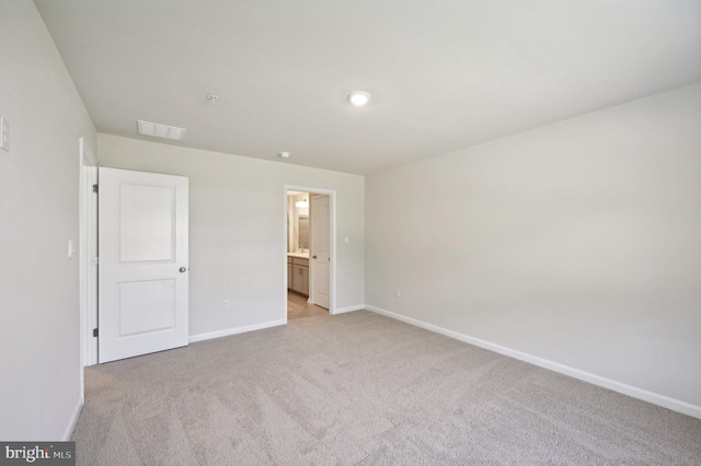 unfurnished bedroom with light carpet and ensuite bath