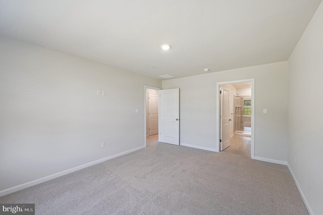 unfurnished bedroom with light carpet and ensuite bath