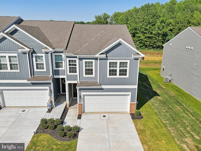 view of front of property with a garage, cooling unit, and a front yard