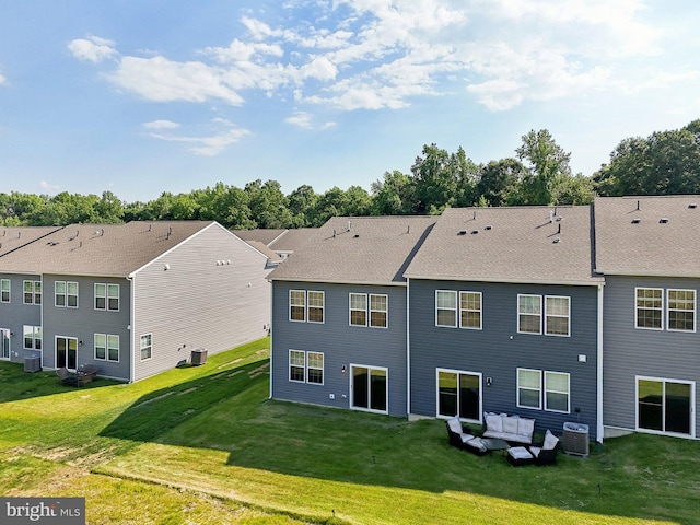 back of property with central AC unit, a lawn, and an outdoor hangout area