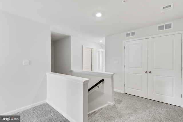 hallway featuring light colored carpet