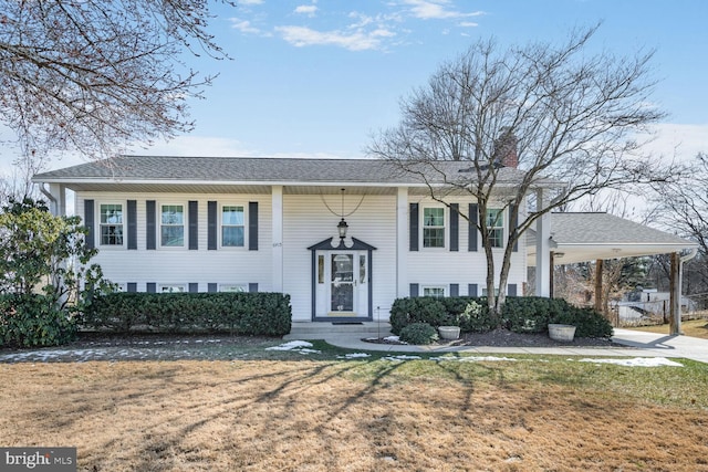 split foyer home featuring a front yard and a carport