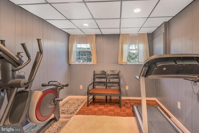 exercise area with a drop ceiling and light parquet flooring