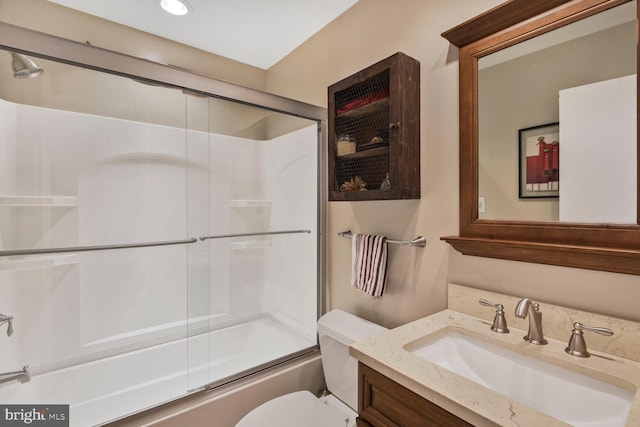 full bathroom featuring toilet, vanity, and shower / bath combination with glass door