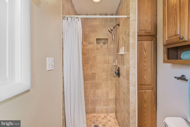 bathroom with toilet and curtained shower