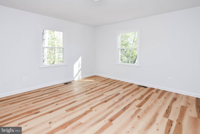 empty room with light hardwood / wood-style flooring