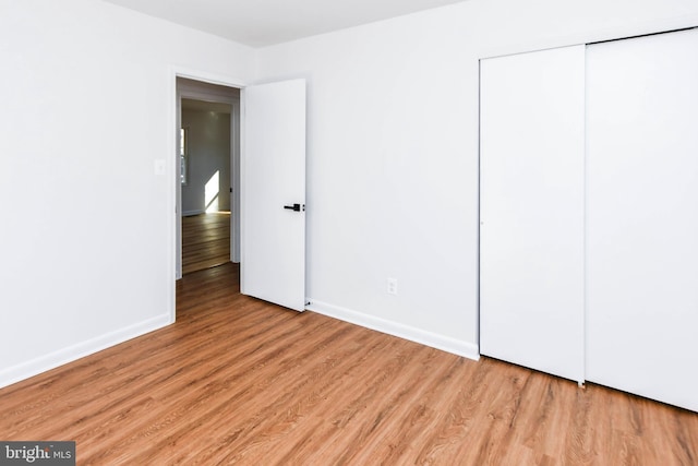 unfurnished bedroom featuring light wood-type flooring and a closet