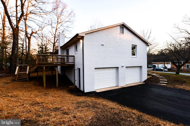 view of side of property featuring a wooden deck and a garage