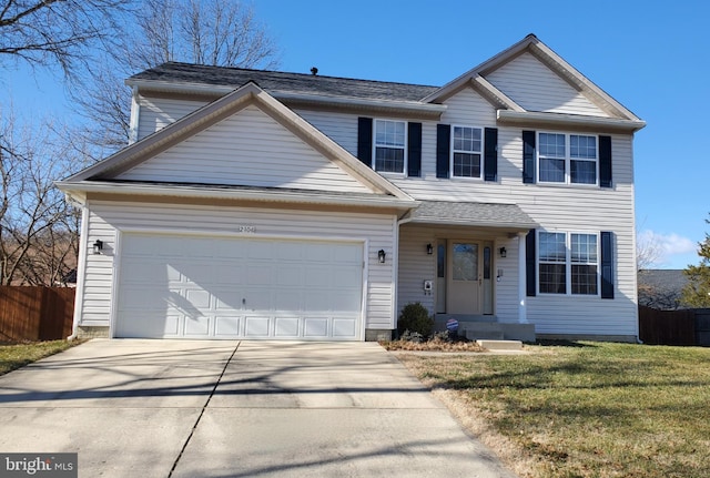 traditional home with a front lawn, concrete driveway, a garage, and fence