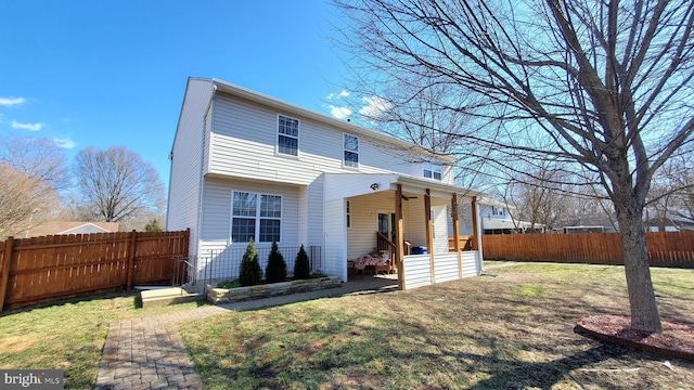 rear view of house featuring a lawn