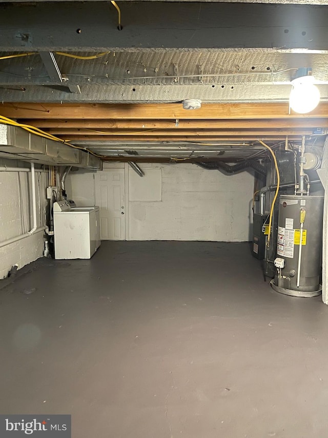 basement featuring heating unit, gas water heater, and independent washer and dryer