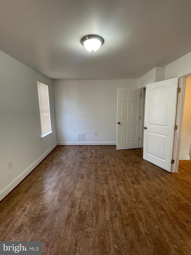 spare room with dark hardwood / wood-style flooring