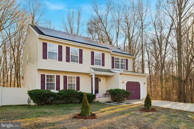 view of front facade featuring a garage, solar panels, and a front lawn