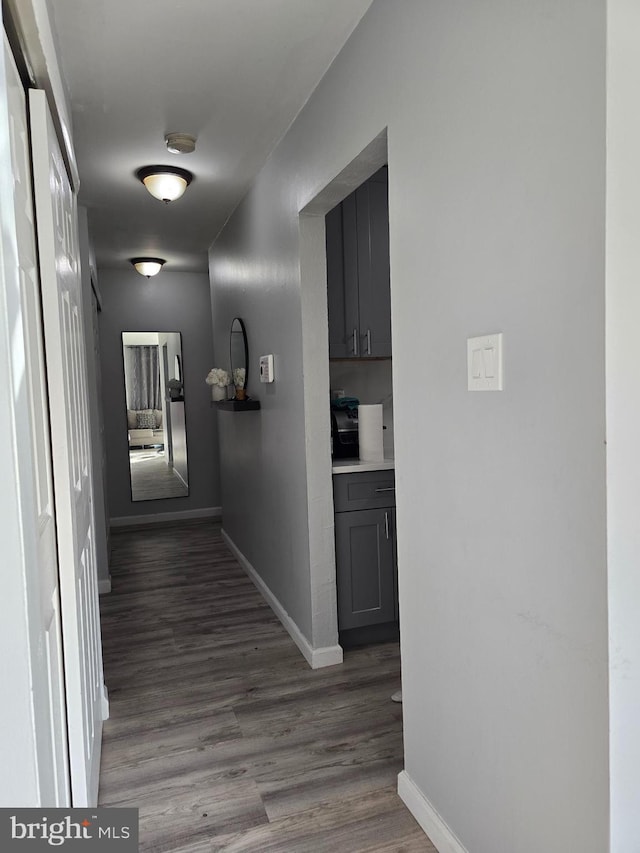 hallway with baseboards and wood finished floors