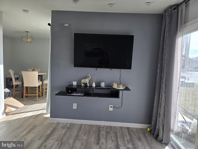 interior space featuring an inviting chandelier, wood finished floors, and baseboards