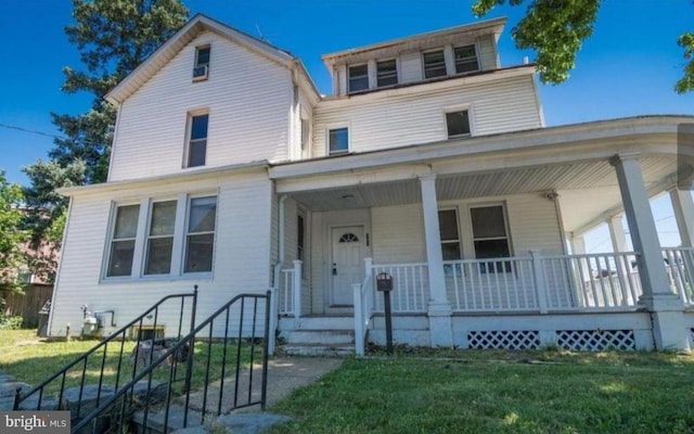 view of front of property featuring covered porch and a front lawn