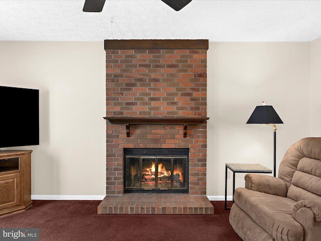 carpeted living area with a fireplace, baseboards, and a textured ceiling