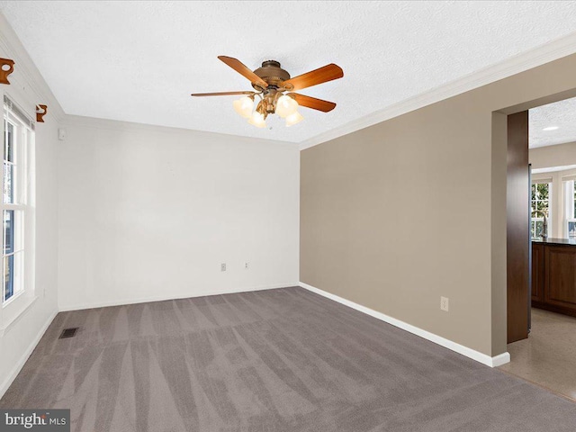 unfurnished room featuring baseboards, visible vents, ornamental molding, a textured ceiling, and carpet flooring