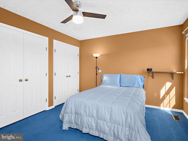 bedroom featuring a ceiling fan, baseboards, carpet, visible vents, and a textured ceiling