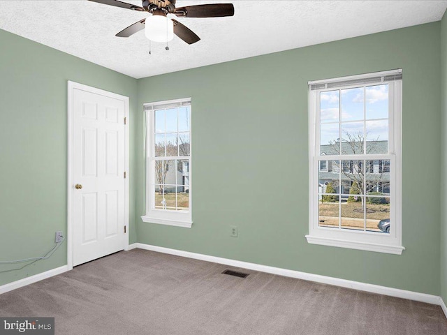 unfurnished bedroom featuring baseboards, multiple windows, and a textured ceiling