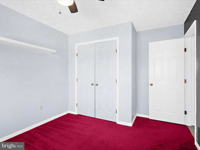 unfurnished bedroom featuring a closet, carpet floors, a textured ceiling, and baseboards