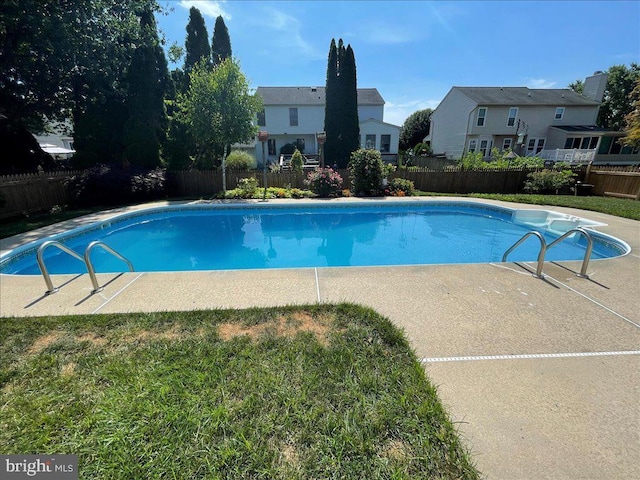 view of swimming pool with a residential view, a fenced in pool, a lawn, and fence